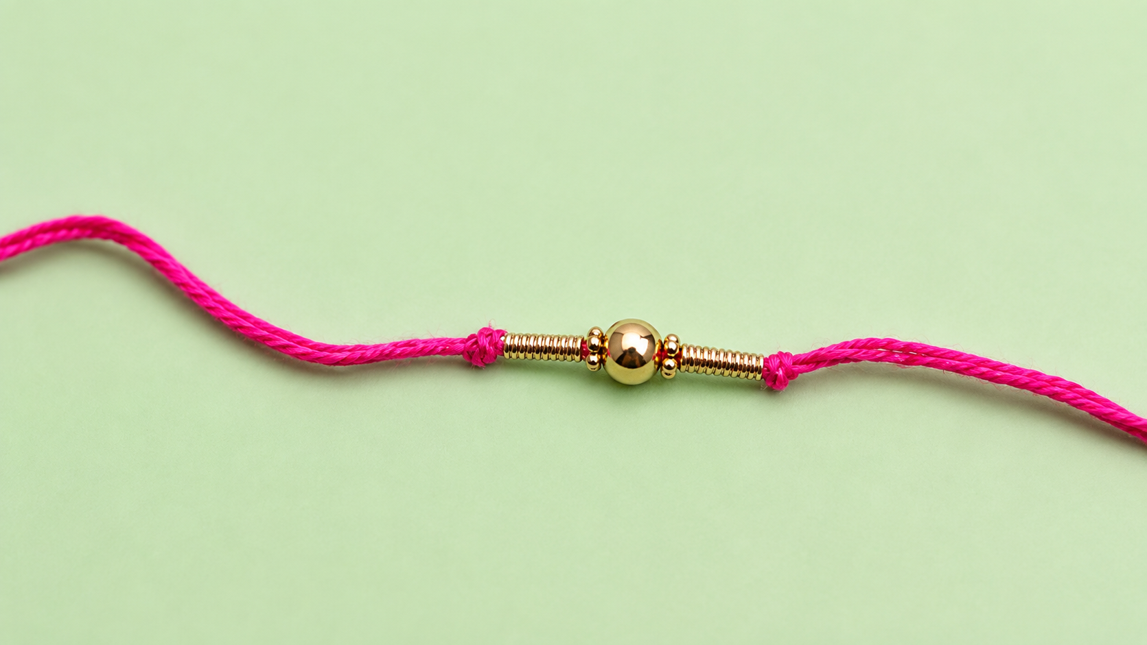 Simple Pink Thread Rakhi with Golden Bead Design